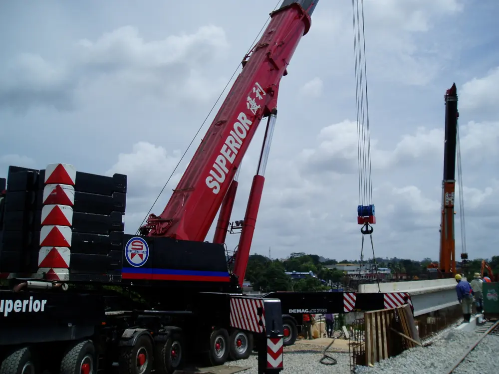 A heavy lift crane assisting with the construction of a train station.