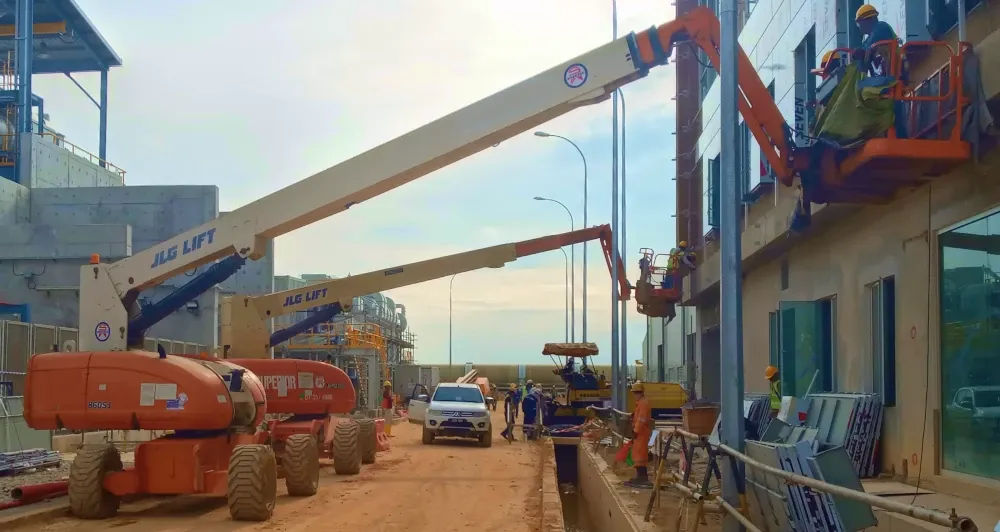 A JLG telescopic boom lift rental being used for maintenance at a power plant.