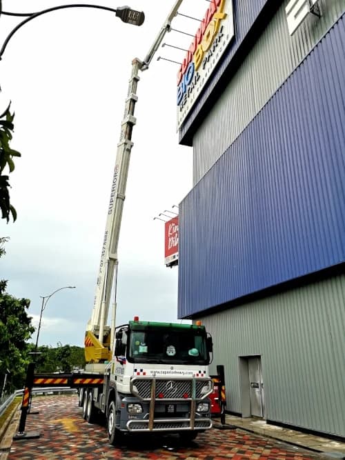A modern skylift with extensive outreach working on a building facade.