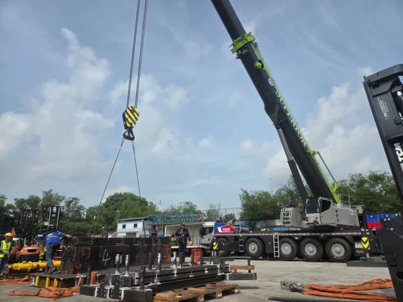 A 300-ton all-terrain crane performing a heavy lift at a construction site.