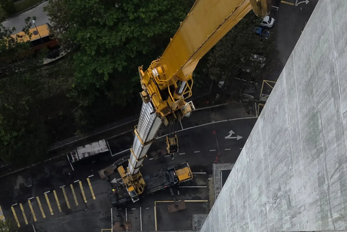 A 200-ton mobile crane with flyjib lifting materials to the roof of the Ministry of Home Affairs building in Johor Bahru.