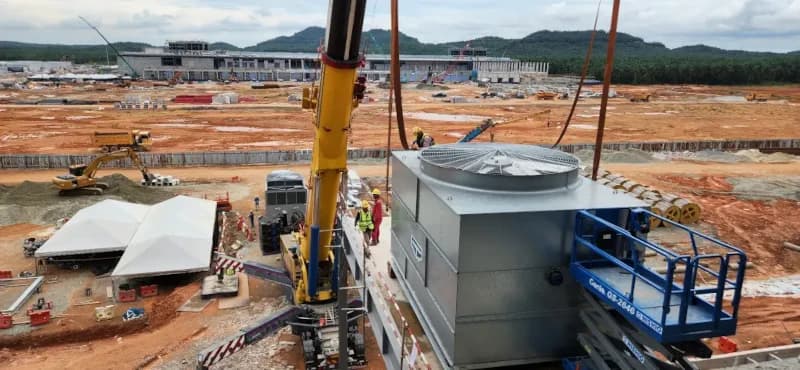 A 300-ton mobile crane lifting a cooling unit onto the data center roof.