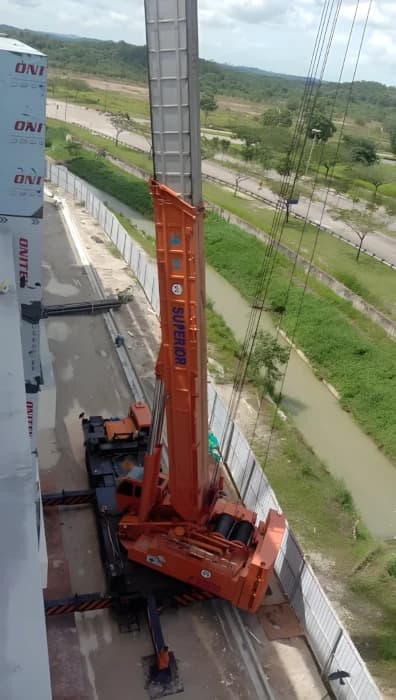 A 160-ton Kato truck crane lifting materials on a construction site.