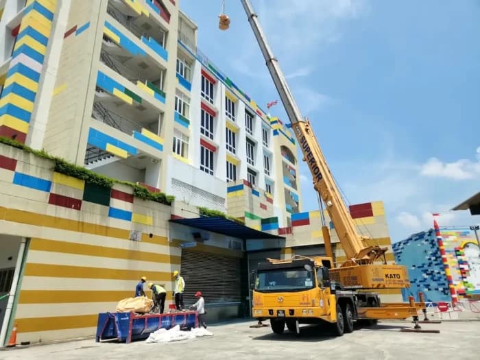 A 50-ton Kato truck crane lifting materials at a construction site.